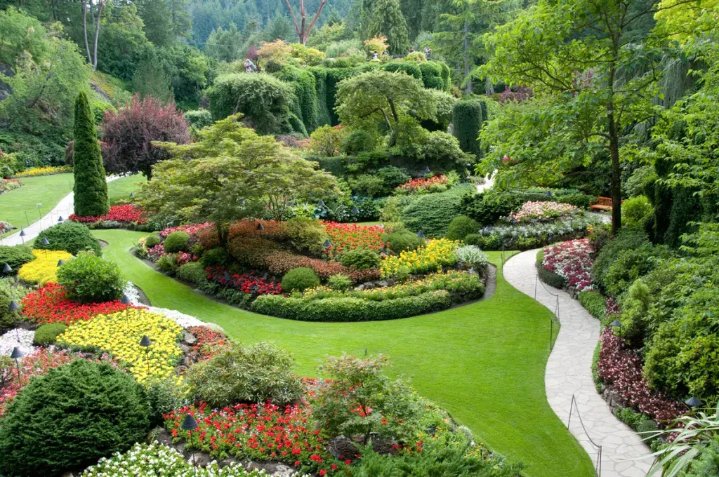 Grand jardin avec pelouse et massifs fleuris bien arrosés