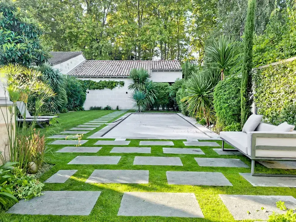 Jardin avec dalles posées dans la pelouse, terrasse et salon de jardin